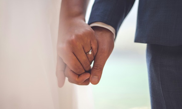 image shows hands holding in marriage