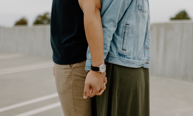 Couple holding hands back to back
