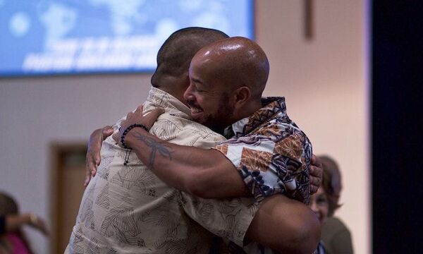 Two guys hugging in room