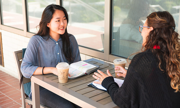 two female students sitting in front of heritage cafe