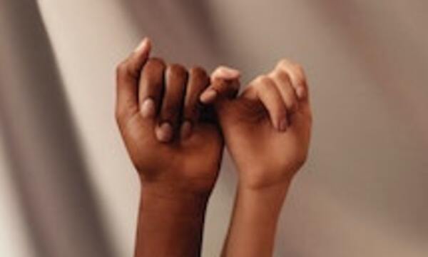 Two hands linking pinky fingers.