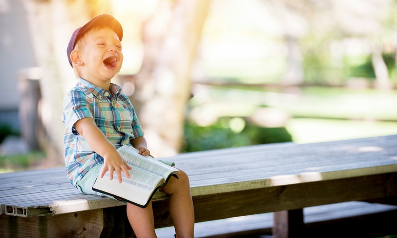 Image shows a child with a Bible