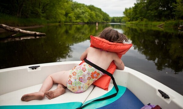 child on with life preserver on a boat