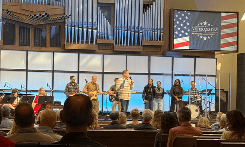 image shows a preacher on stage at St. Andrews
