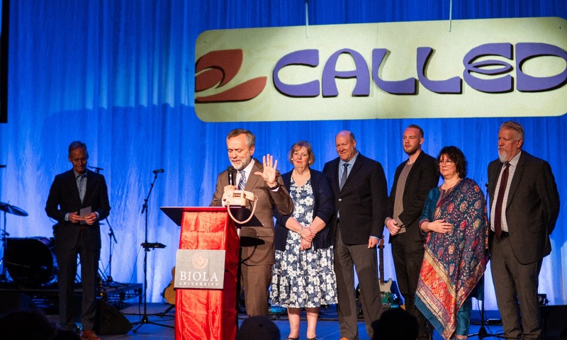 Image shows Barry Corey on stage announcing the name change. 