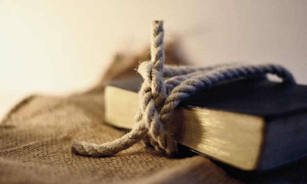 image shows a rope tied around a Bible