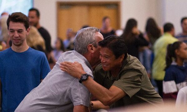 Two church members cordially greeting each other 