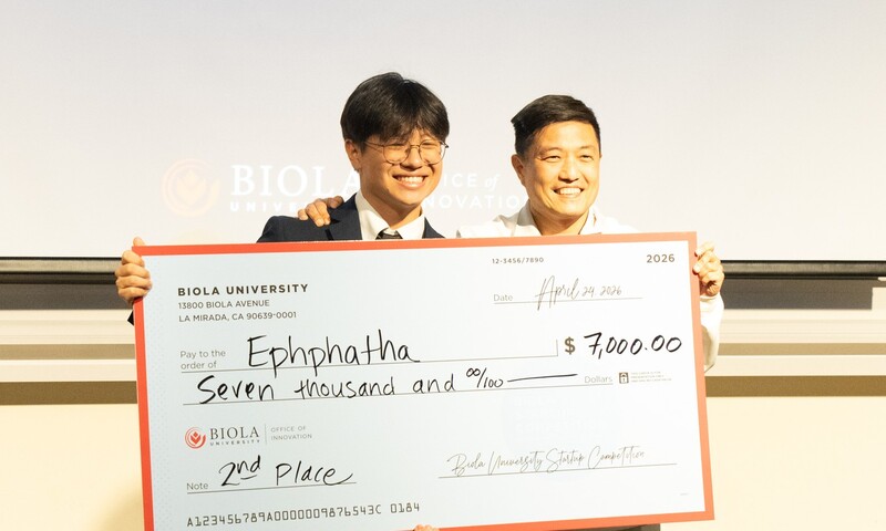 Two men holding an oversized check for $7000