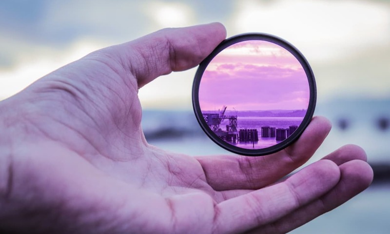 image shows a hand holding a lens
