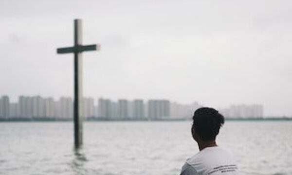 guy looking at distant cross