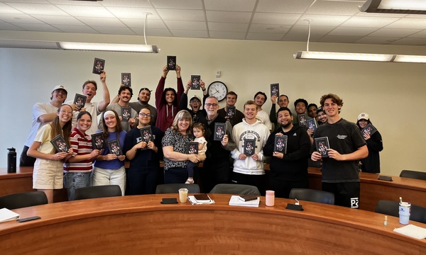 image shows Berding with his students holding his book