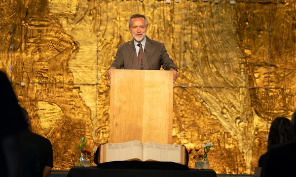 image shows President Barry H. Corey standing before the open Red book