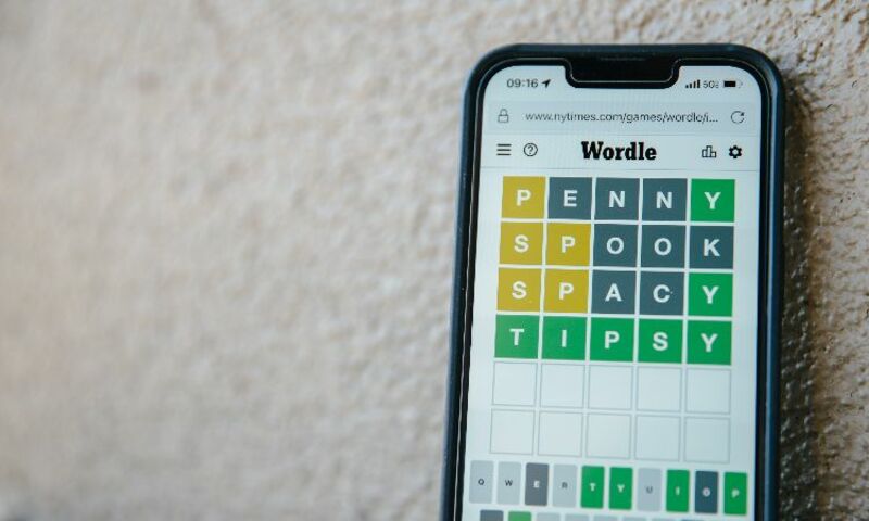 Image shows iPhone sitting on carpet displaying Wordle game