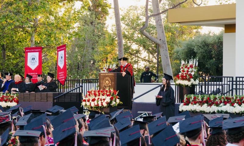 Image shows Dr. Corey speaking at commencement 