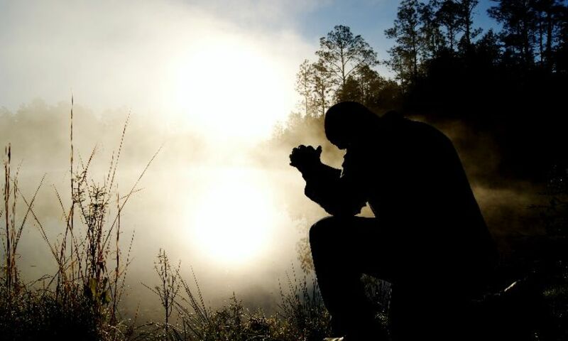 Man praying in solitude on mountain