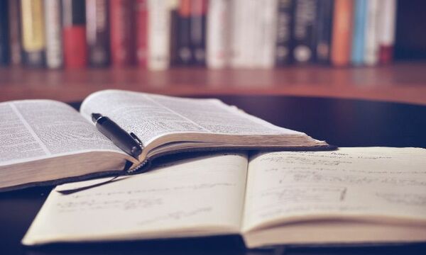 Image shows book and Bible open for reading