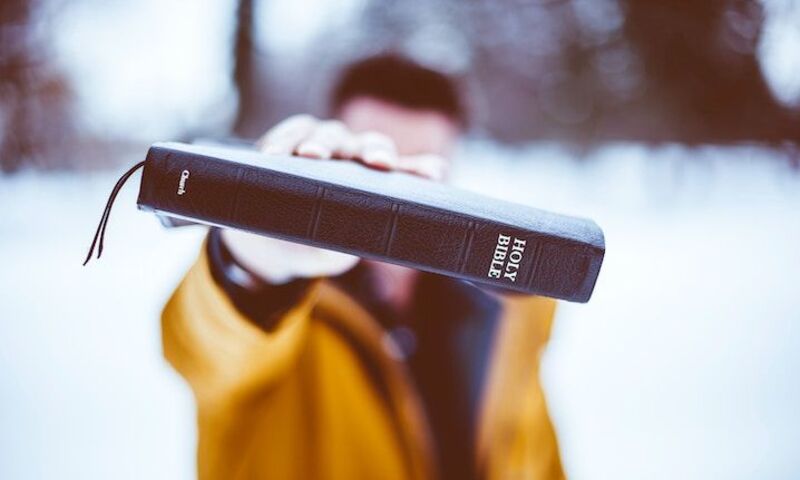 Man holding Bible in snowy climate
