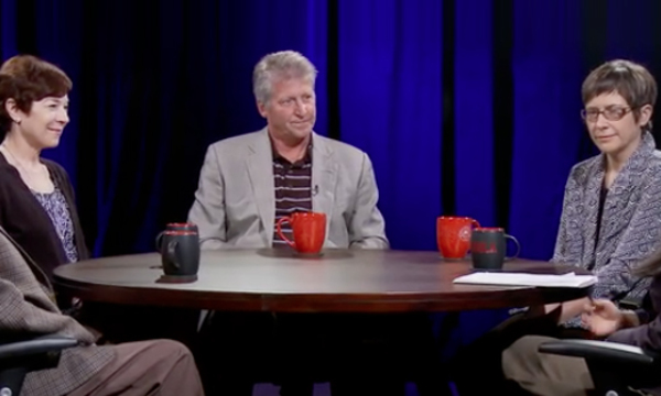 people in a studio seated at a table