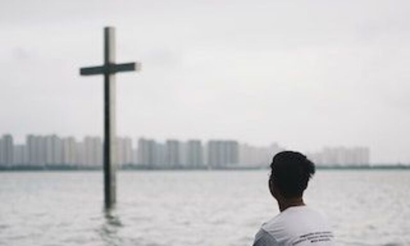 guy looking at distant cross