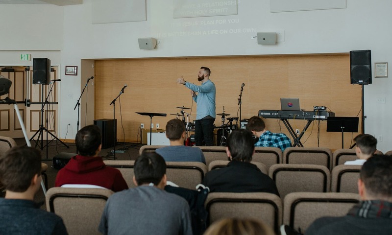 image shows a preacher talking to students