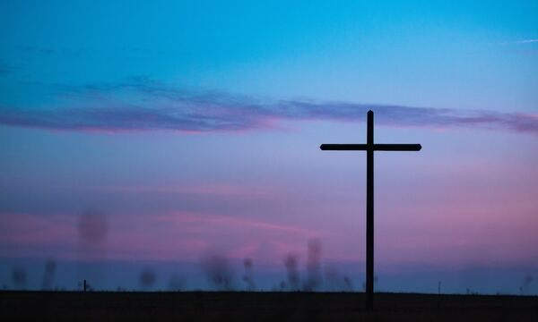 Image shows cross on a hill