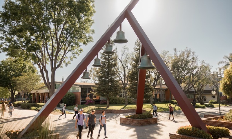 image shows students walking under the Bell Tower