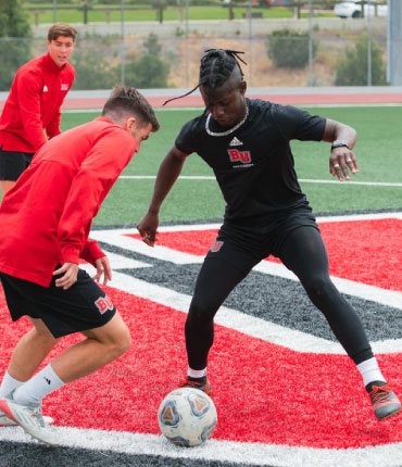 Students playing soccer on a field