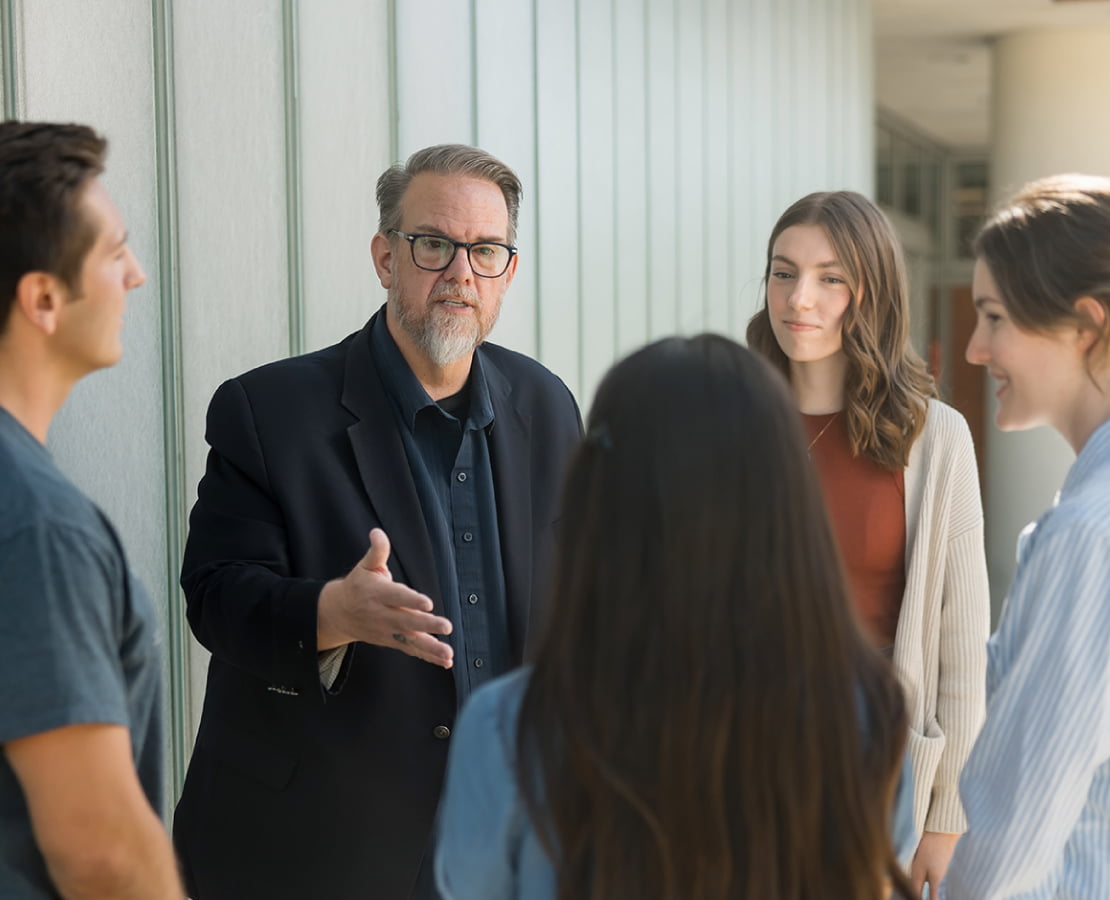 a group of young people talking with Ed Stetzer