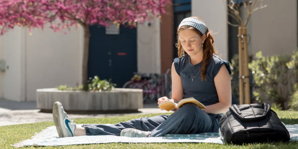 a student reading a book outside