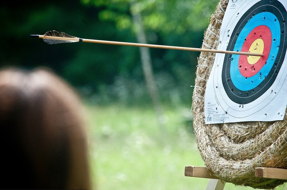 An archery target with an arrow hitting near the center.