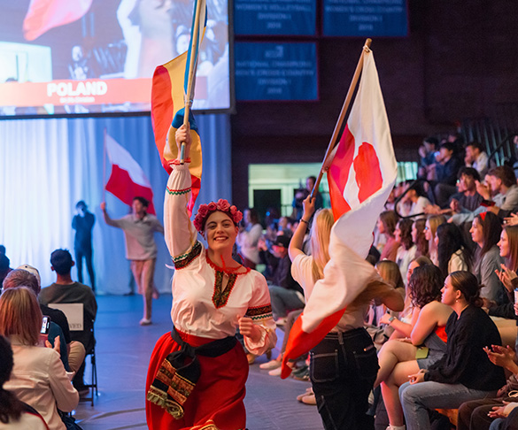 Student smiling and carrying a flag