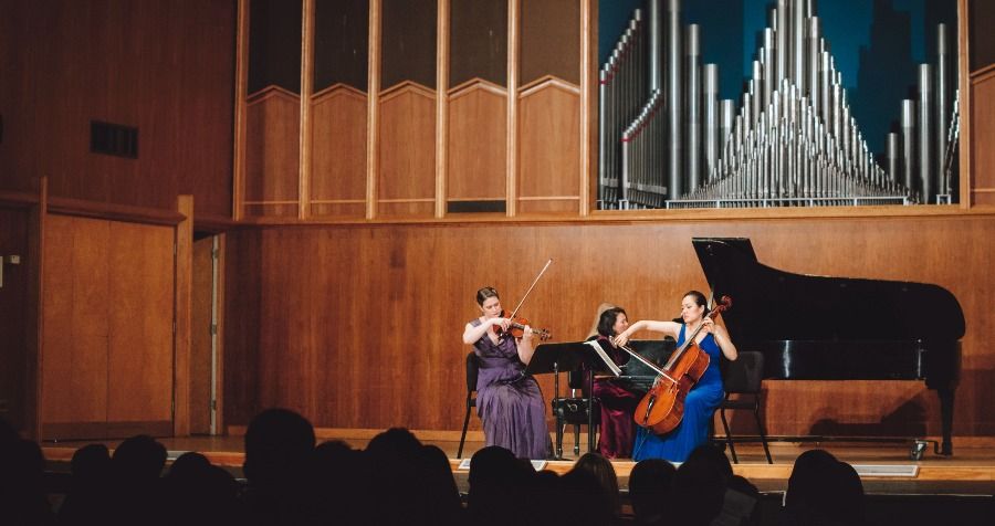 Pianist, cellist, and violinist performing on stage