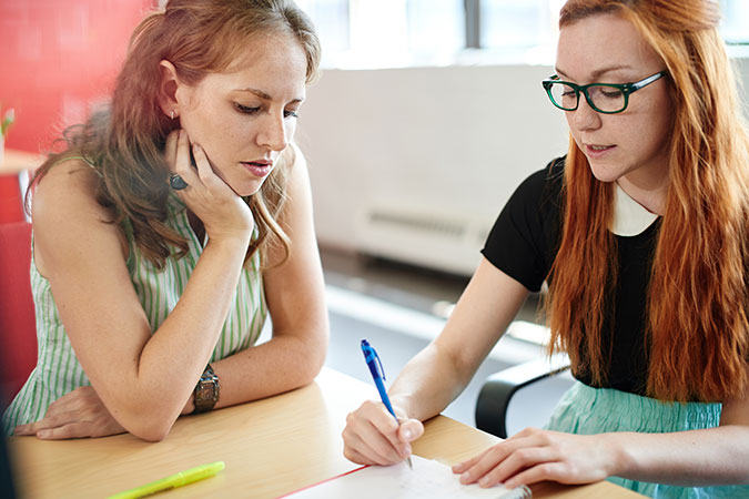 Female student tutoring another student