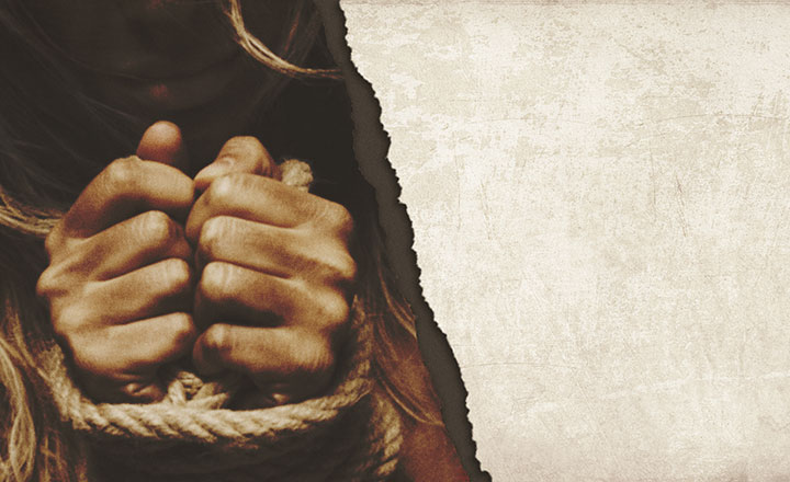 Torn paper revealing hands tied with ropes