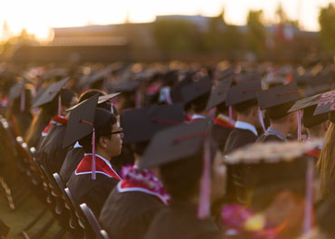 graduates sitting in a row at commencement ceremony