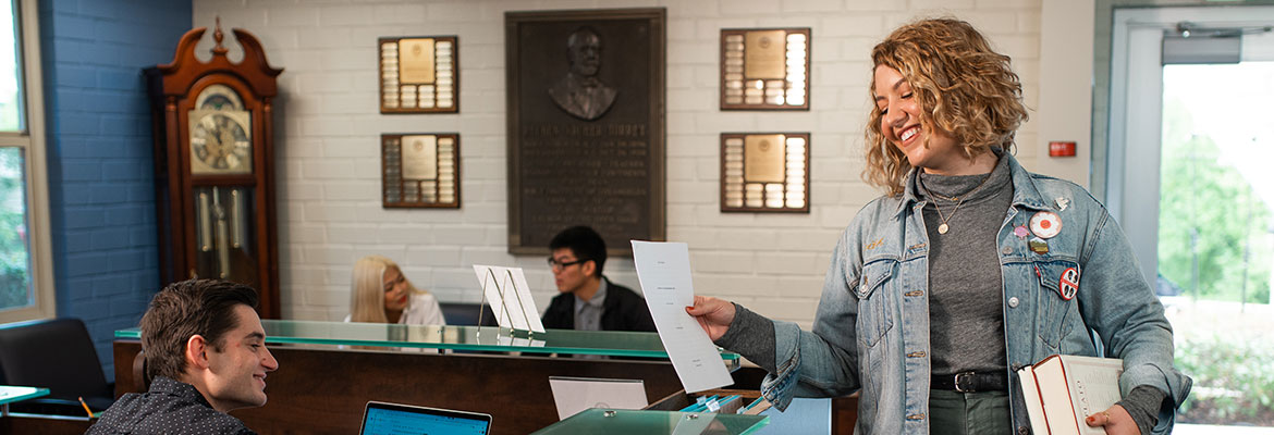 Torrey student holding books in Torrey office