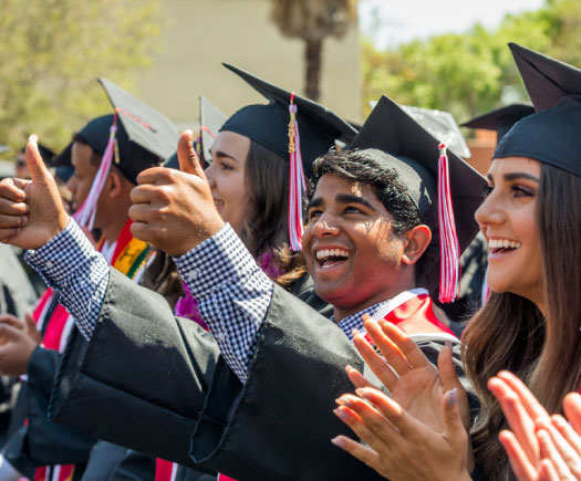 Graduates smiling and holding thumbs up