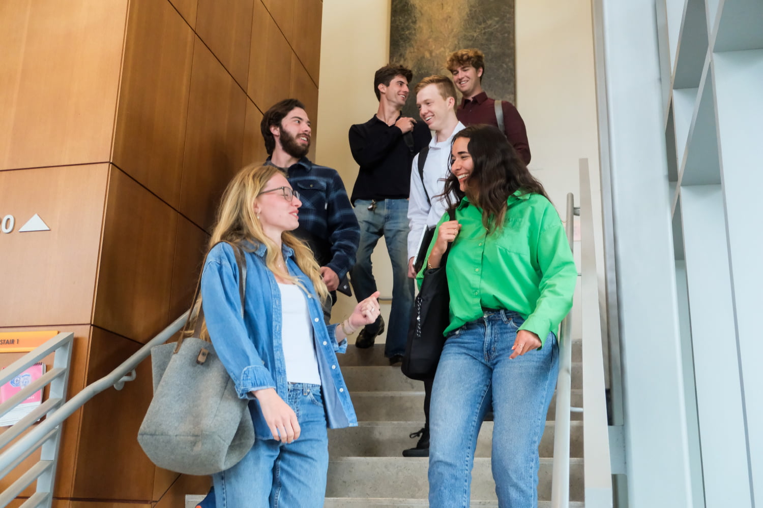 Students walking down stairs together while talking.