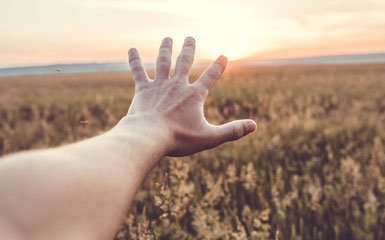 hand reaching out into the horizon