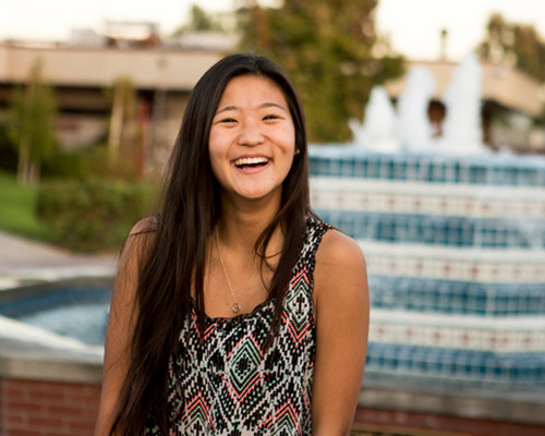 Student standing near the Flour Fountain at Biola University.