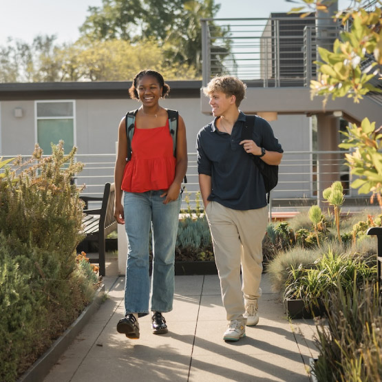 two young people walking and smiling