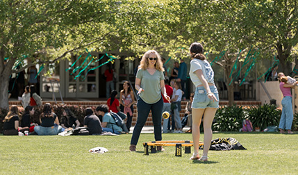 parent and student playing on lawn