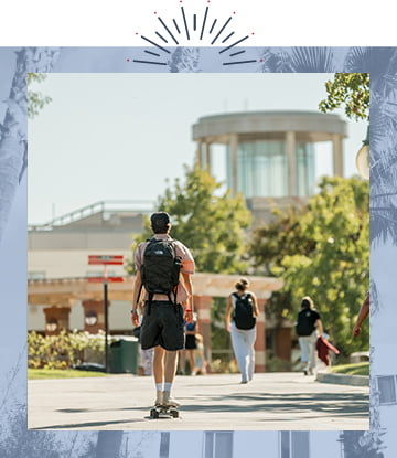 Student rides skateboard down Biola walkway