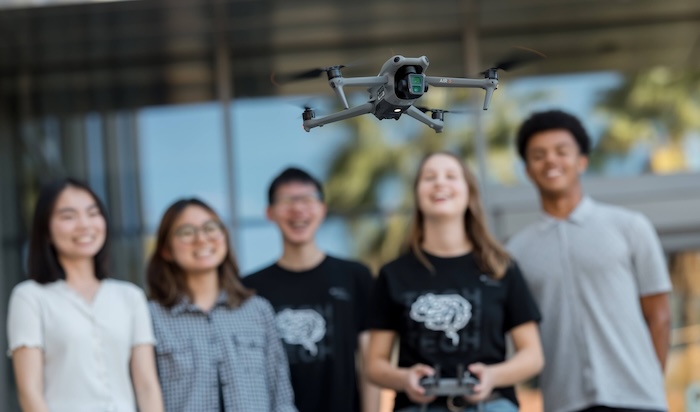 A group of students flying a drone together.