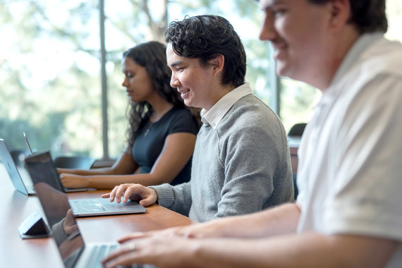 a group of young people using laptops