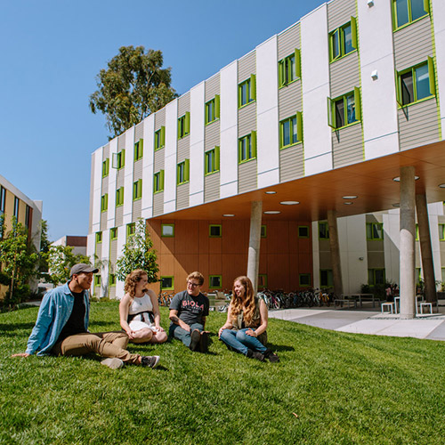 student relaxing in front of a dorm