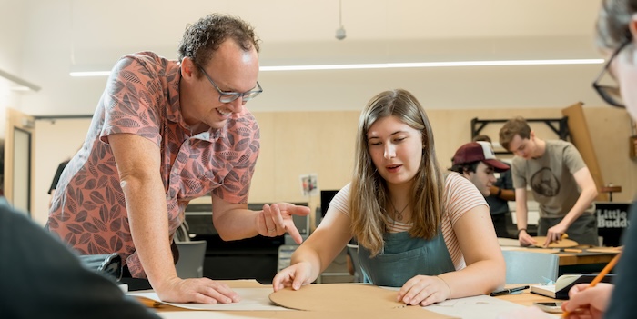 Interior Design teacher reviewing a students work during class