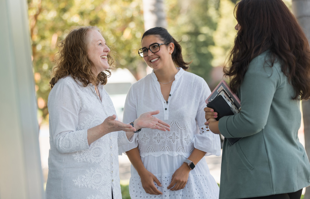 A group of women speaking with books in their hands