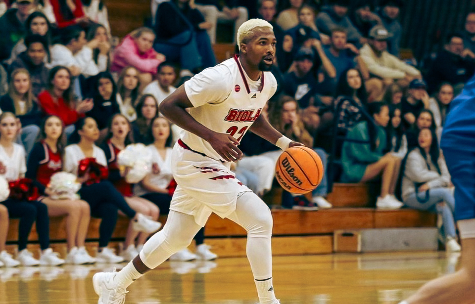 Biola University basketball player mid-stride on the court during a game.