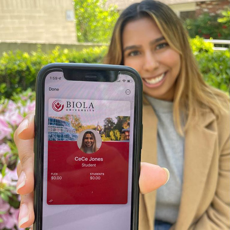 student holding a phone displaying a digital id